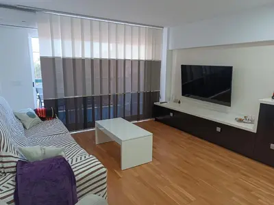 a living room with a couch and a tv at Fleming's Beach in Puebla de Farnals