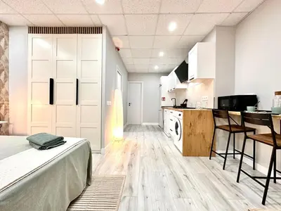 a large room with a bed and a kitchen at Estudio Benicalap in Valencia