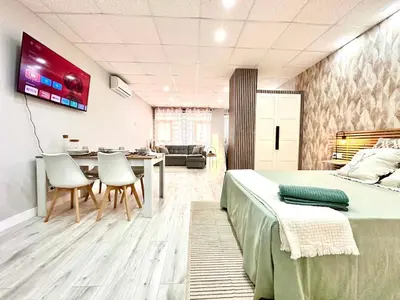 a bedroom with a bed and a table and chairs at Estudio Benicalap in Valencia