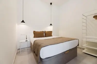 a bedroom with a large bed and two pendant lights at Gran Turia Apartments in Valencia