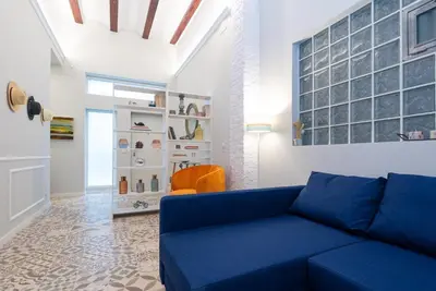 a living room with a blue couch and a chair at Invalencia - Clero Flat Suite in Valencia