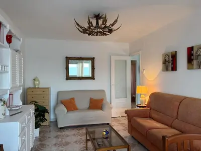 a living room with a couch and a chandelier at Relax & Sea View & Beach Access in Faro de Cullera