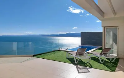 a patio with two chairs and a view of the water at 3 Bedroom Beautiful Home In Cullera in Cullera