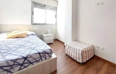a bedroom with a bed and a stool in it at 3 Bedroom Beautiful Home In Cullera in Cullera