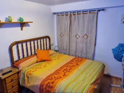 a bedroom with a bed with an orange pillow on it at Casa Amando in Chulilla
