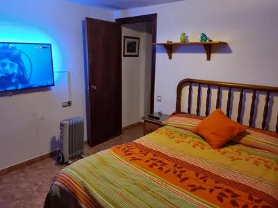 a bedroom with a bed and a flat screen tv at Casa Amando in Chulilla