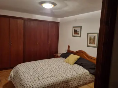 a bedroom with a bed and wooden cabinets at Casa Amando in Chulilla
