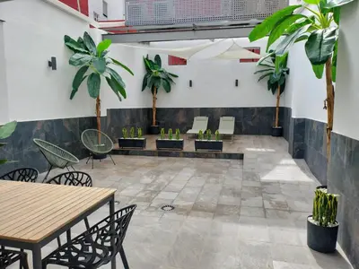 a room with tables and chairs and potted plants at Travel Habitat Ruzafa Green House Terrace in Valencia