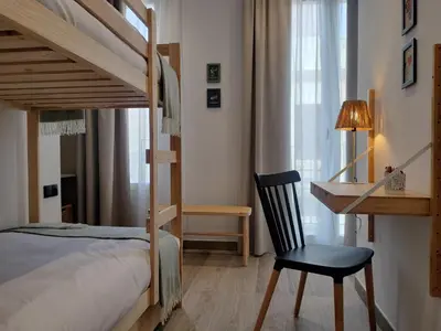 a bedroom with a bunk bed and a desk and a chair at Travel Habitat Ruzafa Green House Terrace in Valencia