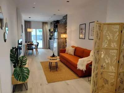 a living room with a orange couch and a table at Travel Habitat Ruzafa Green House Terrace in Valencia