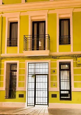 a yellow building with black gates and windows at Travel Habitat Ruzafa Green House Terrace in Valencia
