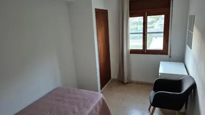 a bedroom with a bed and a chair and a window at CANET de BERENGUER in Canet de Berenguer