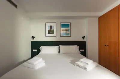 a bedroom with a white bed with towels on it at Seaview Flat Patacona in Valencia