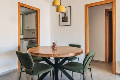 a dining room with a wooden table and green chairs at Seaview Flat Patacona in Valencia