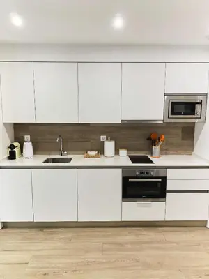 a white kitchen with a sink and a microwave at Central Market Deluxe Apartments in Valencia
