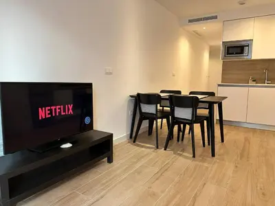 a living room with a table and chairs and a tv at Central Market Deluxe Apartments in Valencia
