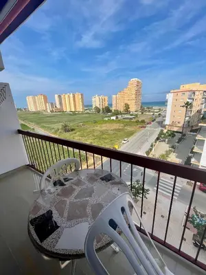 a balcony with a table and a view of a city at Apto Playa Puebla de Farnals cerca de Valencia in Puebla de Farnals
