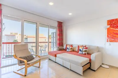 a living room with a couch and a chair at Apto Playa Puebla de Farnals cerca de Valencia in Puebla de Farnals