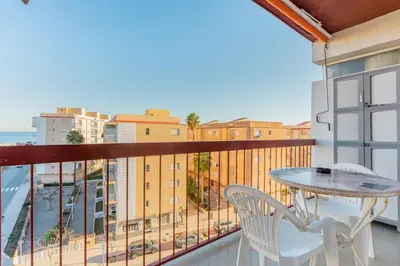 a balcony with a table and chairs and a view of the ocean at Apto Playa Puebla de Farnals cerca de Valencia in Puebla de Farnals