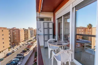 a balcony with a table and chairs and a view of a city at Apto Playa Puebla de Farnals cerca de Valencia in Puebla de Farnals