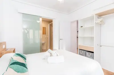 a bedroom with a white bed with towels on it at Confortable apto en la playa a 10min de Valencia in Valencia
