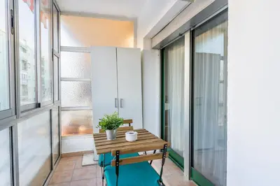 a small balcony with a wooden table with a potted plant at Confortable apto en la playa a 10min de Valencia in Valencia