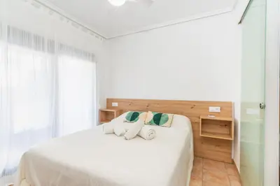 a bedroom with a white bed with towels on it at Confortable apto en la playa a 10min de Valencia in Valencia