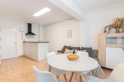 a living room with a white table and chairs at Confortable apto en la playa a 10min de Valencia in Valencia