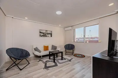 a living room with a couch and chairs and a tv at Apartamento en el Cabanyal enfrente de la Marina Real in Valencia