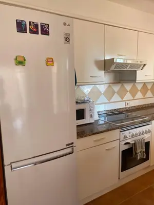 a white refrigerator in a kitchen with a microwave at Casa Ivan in Tavernes de Valldigna