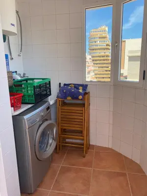 a laundry room with a washing machine and a window at Casa Ivan in Tavernes de Valldigna