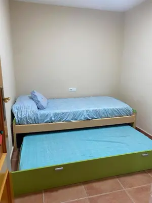 a small room with two beds with blue sheets at Casa Ivan in Tavernes de Valldigna