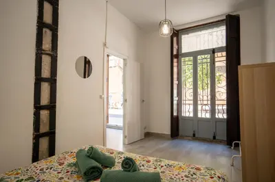 a bedroom with a bed and a door with a window at Luminoso Apartamento Familiar y Patio Privado in Valencia