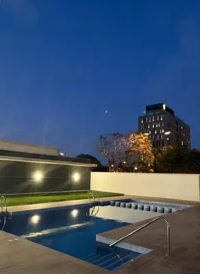 a swimming pool at night with a building in the background at Apartamento Luxury in Valencia