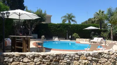 a swimming pool with a table and chairs and an umbrella at Casa Kiosko 2 bedroom chalet with swimming pool in La Eliana