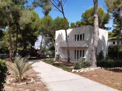 a white house in the middle of trees at Casa Kiosko 2 bedroom chalet with swimming pool in La Eliana