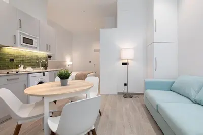 a kitchen and a living room with a table and a couch at Apartamento 3º nuevo a estrenar cerca del mar in Valencia