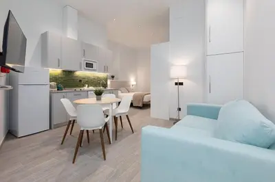a living room with a couch and a table and chairs at Apartamento 3º nuevo a estrenar cerca del mar in Valencia