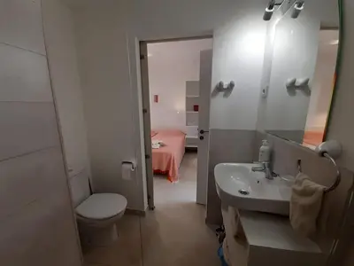 a bathroom with a sink and a toilet and a bed at Casa Kiosko 3 bedroom chalet with swimming pool in La Eliana