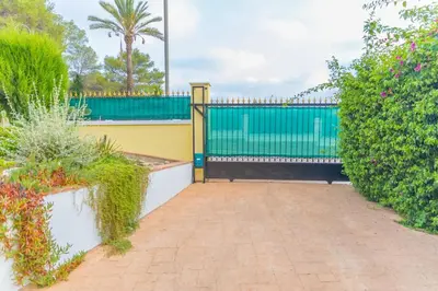 a driveway with a gate and some plants at Luxury villa close to beach, mountain and golf! in Alzira