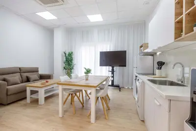 a kitchen and living room with a table and a couch at Apartamentos Grupo Torres de Quart in Valencia