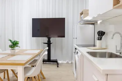 a kitchen with a table and a television on a tripod at Apartamentos Grupo Torres de Quart in Valencia