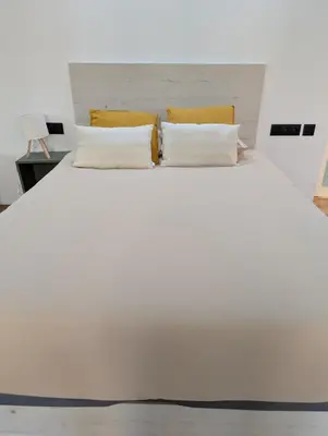 a white bed with two pillows on top of it at Las Arenas Suites 3 in Valencia