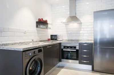 a kitchen with a stainless steel refrigerator and a dishwasher at Apartamentos La Marina in Valencia