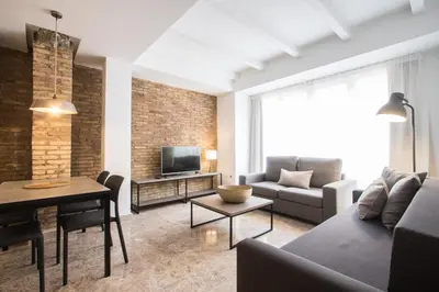 a living room with a couch a table and a tv at Apartamentos La Marina in Valencia