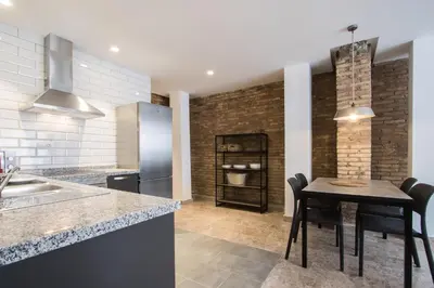 a kitchen with a table with chairs and a counter top at Apartamentos La Marina in Valencia