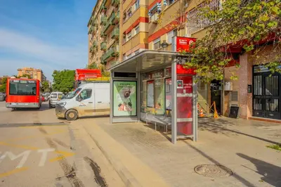 a bus stop on a city street with a bus at Vlc Yako Suite in Valencia