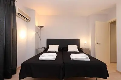 a bedroom with a black bed with towels on it at Apartamento Plaza Reina in Valencia