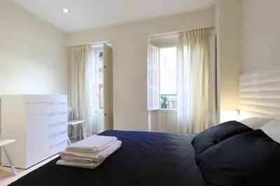 a bedroom with a bed and a dresser and a window at Apartamento Plaza Reina in Valencia