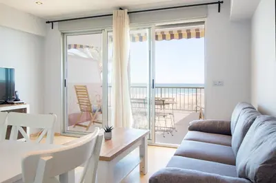 a small kitchen with a microwave and a sink at Global Vacacional, Apartamento en primera linea con impresionantes vistas al mar in Canet de Berenguer